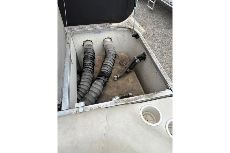 Slide: The Image of 2004 Sun Tracker Party Barge 25 I/O Regency Edition storage compartment with hoses and fittings. - 16