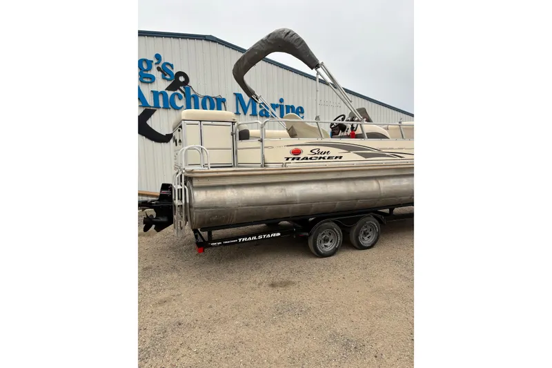 Slide: The Image of 2004 Sun Tracker Party Barge 25 I/O Regency Edition on trailer near marine shop. - 4