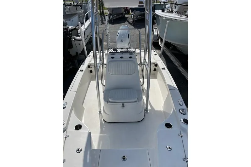 Slide: The Image of 2024 Palmetto 186 boat interior with seating and console, docked among other boats. - 5