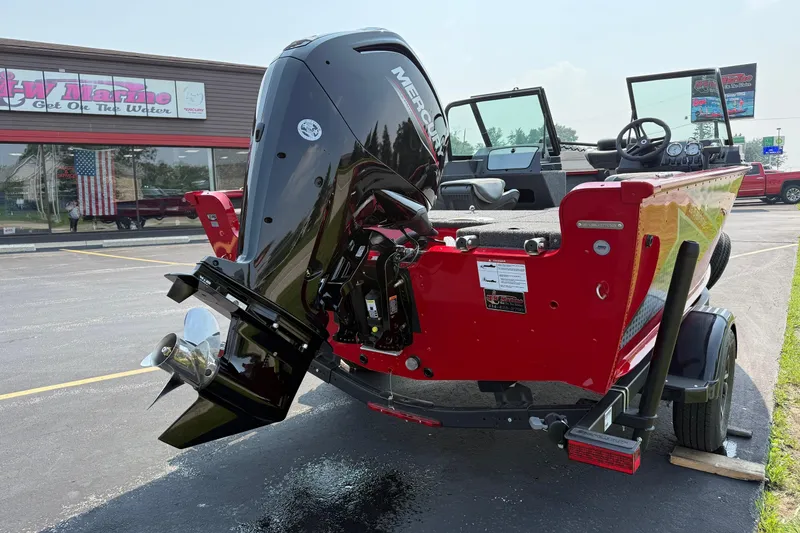 Slide: The Image of 2025 Lund 1675 Adventure Sport boat with Mercury engine, parked outside a marine store. - 4
