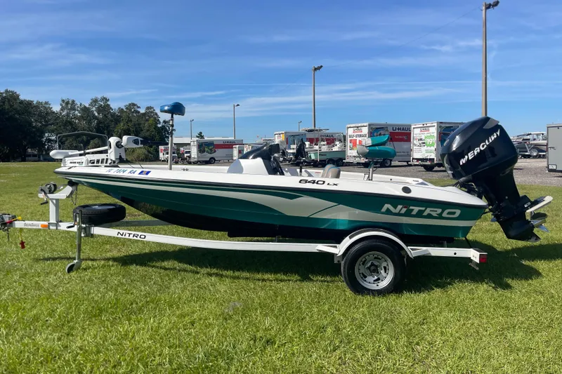 The Image of 2006 Nitro 640 LX boat with Mercury engine on trailer, parked on grass. - 1