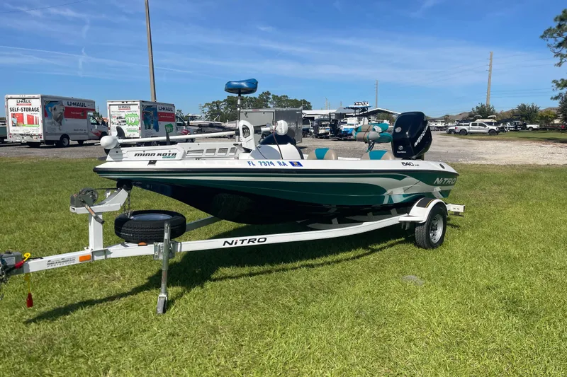 Slide: The Image of 2006 Nitro 640 LX boat on trailer, parked on grass, with U-Haul trucks in background. - 7