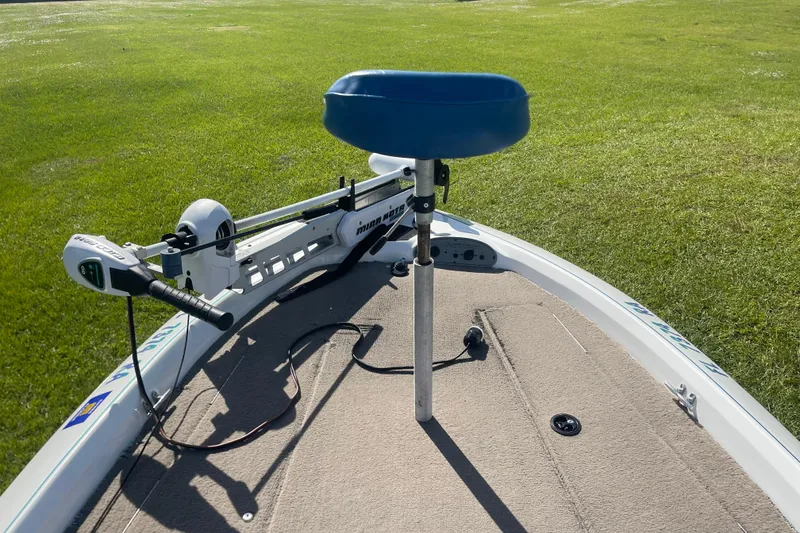 Slide: The Image of 2006 Nitro 640 LX boat with trolling motor and blue seat on grassy area. - 9