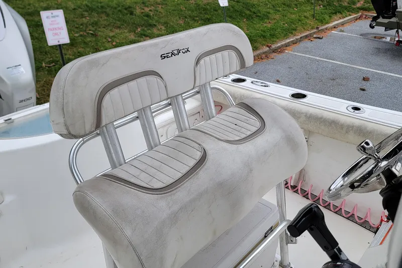 Slide: The Image of 2010 Sea Fox 216 Center Console boat seat and steering wheel in a parking area. - 12