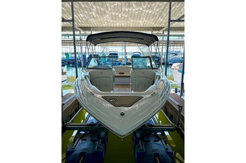 Slide: The Image of 2010 Cobalt 232 boat docked in a marina, featuring sleek design and spacious seating. - 16