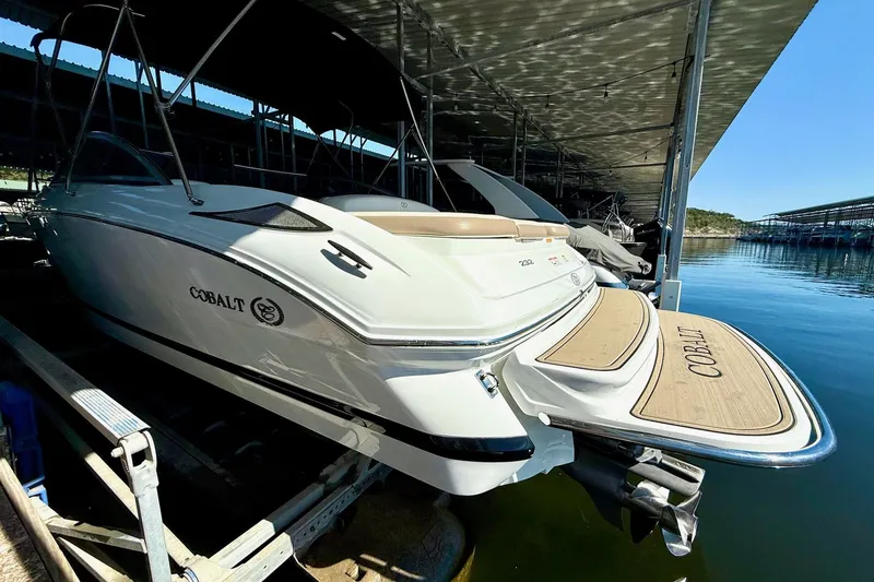 Slide: The Image of 2010 Cobalt 232 boat docked in a marina, showcasing sleek design and branding. - 18