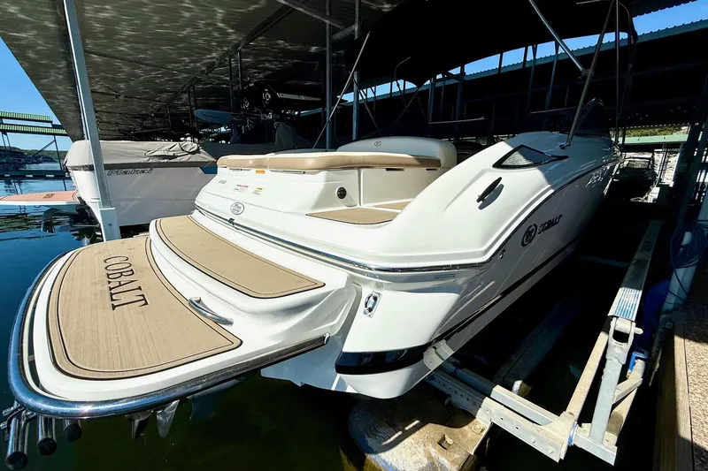 Slide: The Image of 2010 Cobalt 232 boat docked in a marina, showcasing sleek design and branding. - 19