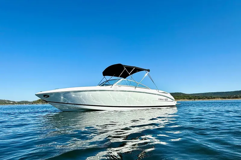 Slide: The Image of 2010 Cobalt 232 boat on calm water under clear blue sky. - 2