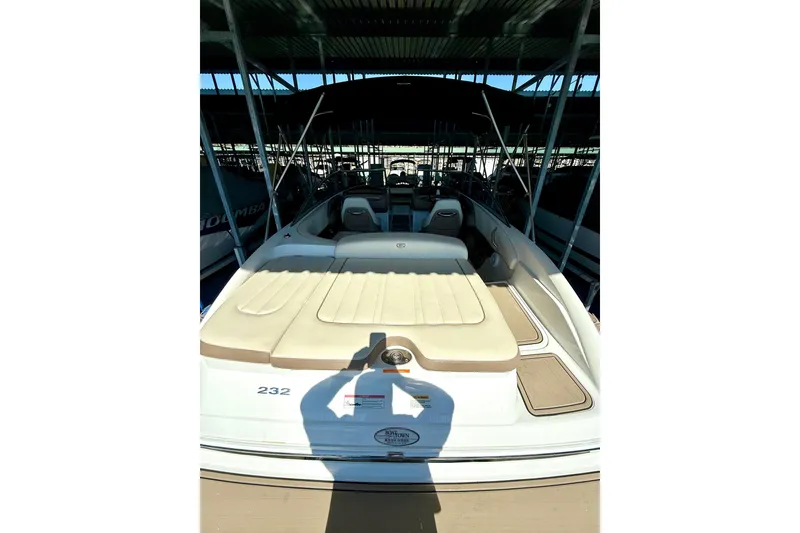 Slide: The Image of 2010 Cobalt 232 boat with beige seating, docked in a covered marina. - 20