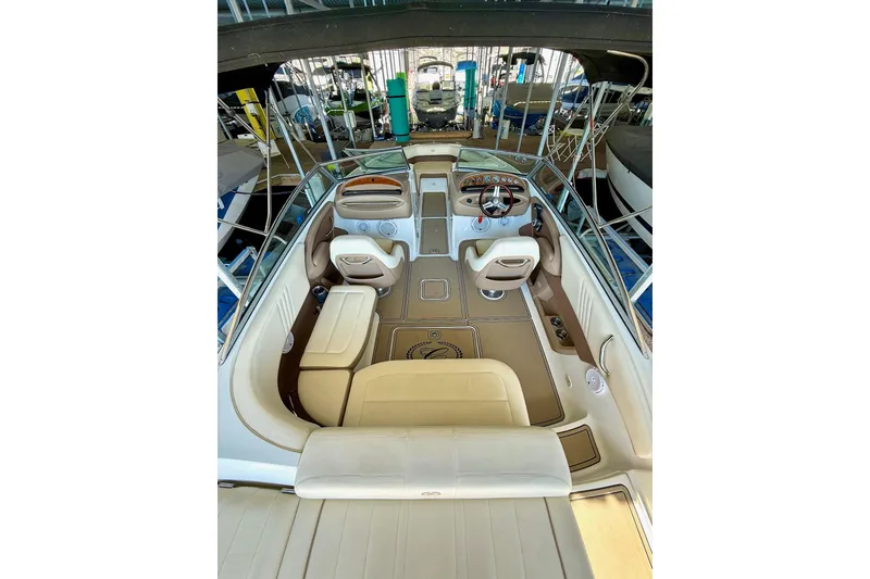 Slide: The Image of 2010 Cobalt 232 boat interior with beige seating and steering console. - 21