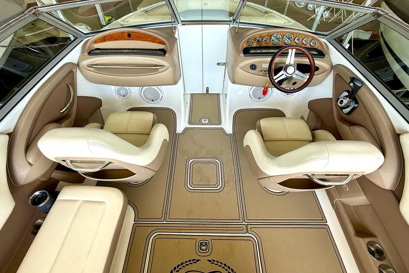 Slide: The Image of Interior of a 2010 Cobalt 232 boat with beige seating and wood accents. - 23