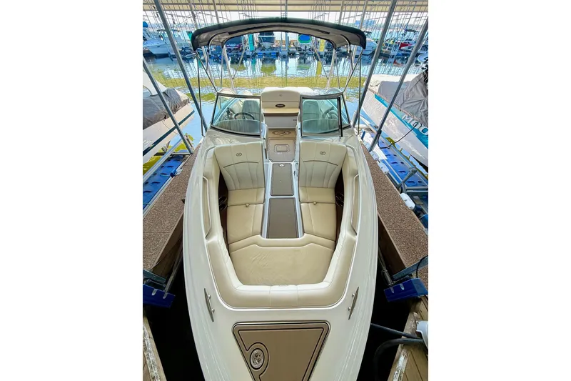 Slide: The Image of 2010 Cobalt 232 boat with beige interior, docked in a marina. - 24