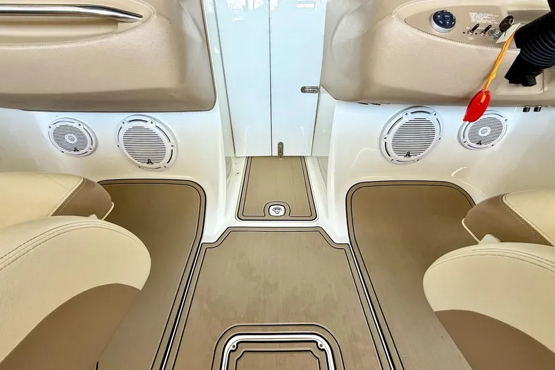 Slide: The Image of Interior of a 2010 Cobalt 232 boat featuring beige seating and integrated speakers. - 28