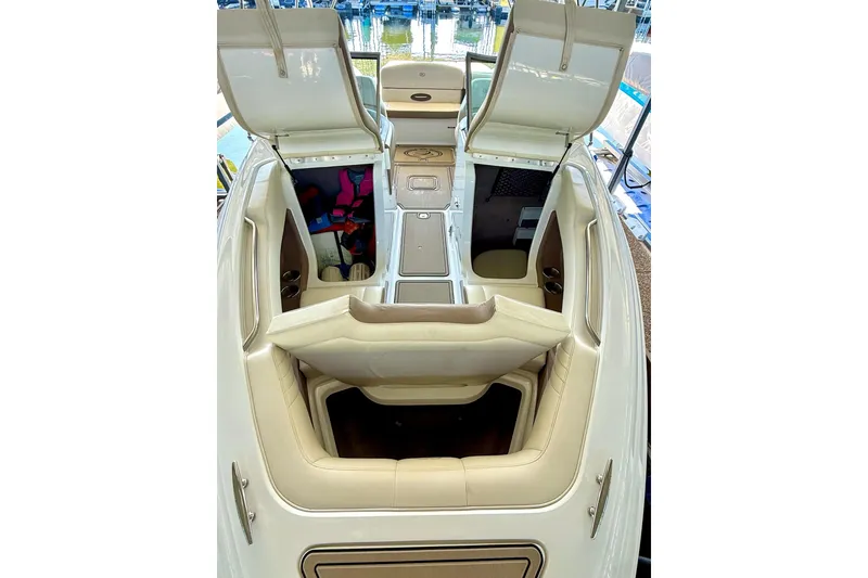 Slide: The Image of 2010 Cobalt 232 boat interior with open storage compartments and beige seating. - 29