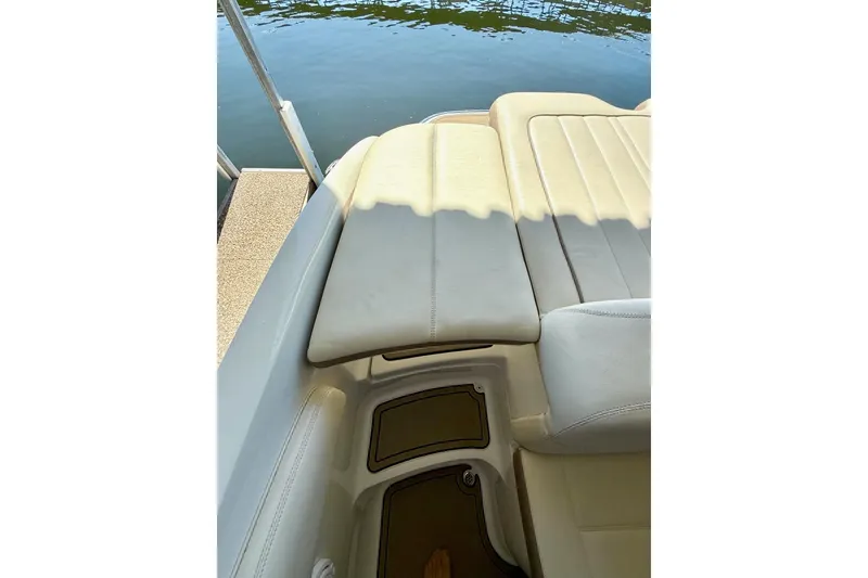 Slide: The Image of 2010 Cobalt 232 boat interior with beige seating near water. - 32