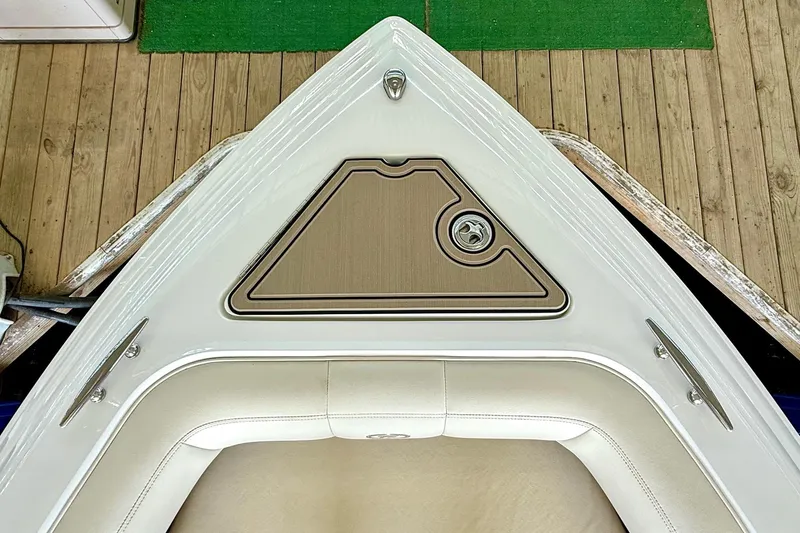 Slide: The Image of Bow of 2010 Cobalt 232 boat with cushioned seating and storage compartment. - 33