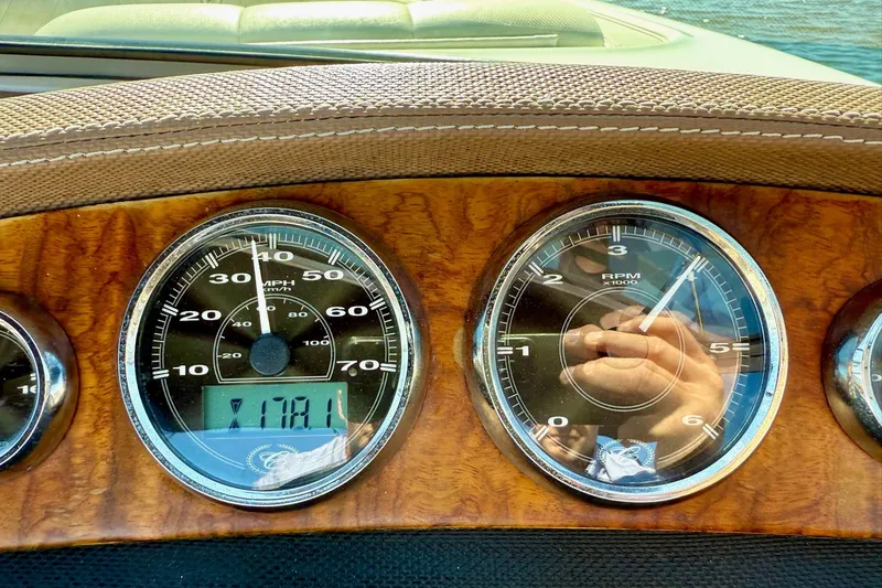 Slide: The Image of Dashboard of a 2010 Cobalt 232 boat with wood finish and analog gauges. - 36