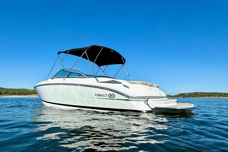 Slide: The Image of 2010 Cobalt 232 boat on calm water under clear blue sky. - 4