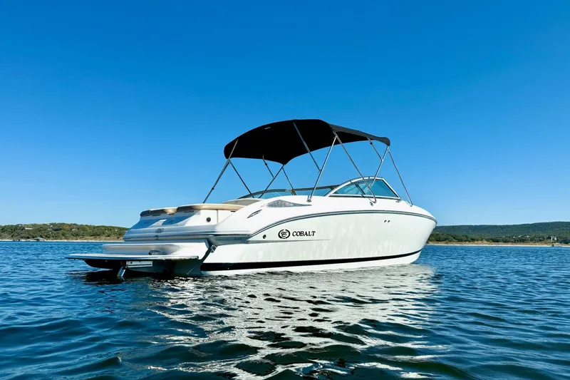 Slide: The Image of 2010 Cobalt 232 boat on calm water under clear blue sky. - 6