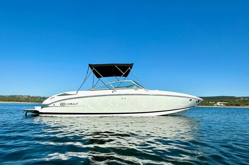 Slide: The Image of 2010 Cobalt 232 boat on calm water under clear blue sky. - 7