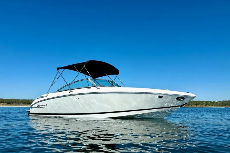 Slide: The Image of 2010 Cobalt 232 boat on calm water under clear blue sky. - 8