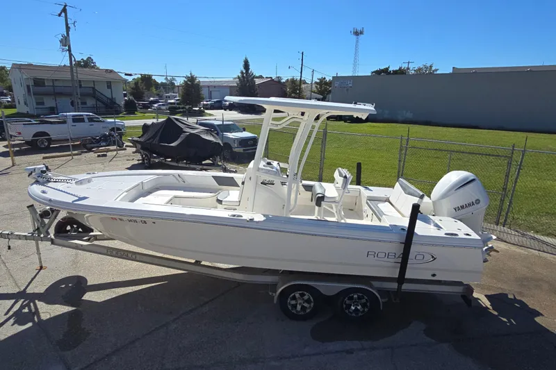 Slide: The Image of 2019 Robalo 246 Cayman boat on trailer, parked outdoors, featuring Yamaha outboard motor. - 11
