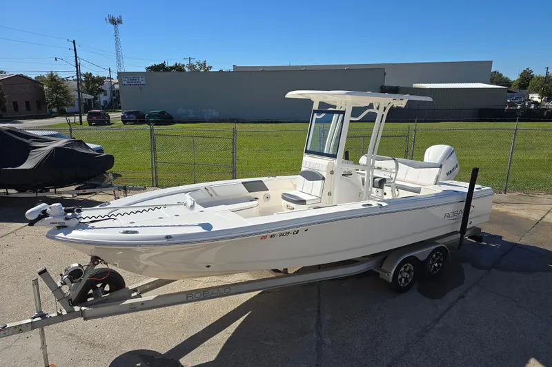 Slide: The Image of 2019 Robalo 246 Cayman boat on trailer, parked outdoors on a sunny day. - 12