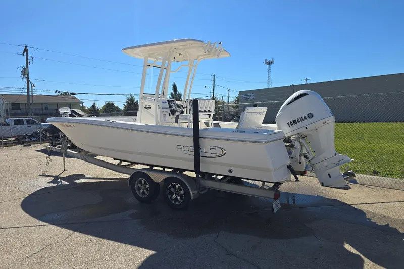 Slide: The Image of 2019 Robalo 246 Cayman boat on trailer with Yamaha outboard motor, parked outdoors. - 2