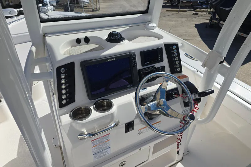 Slide: The Image of 2019 Robalo 246 Cayman boat dashboard with steering wheel and navigation controls. - 22