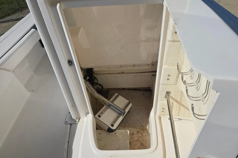Slide: The Image of Storage compartment on a 2019 Robalo 246 Cayman boat, featuring rod holders and equipment. - 25
