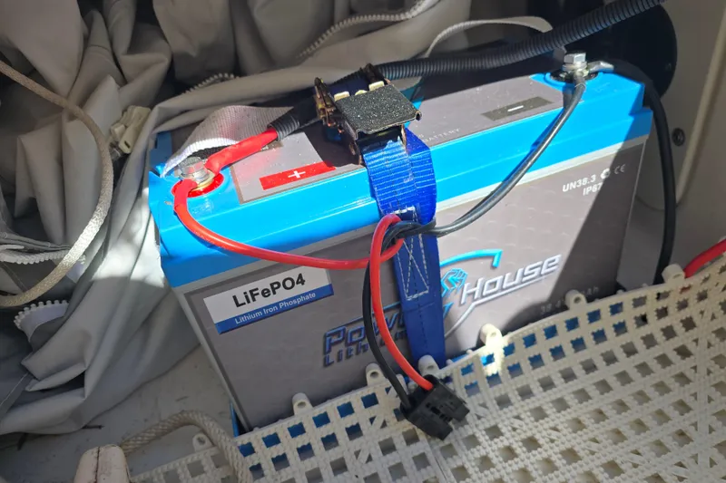 Slide: The Image of Lithium iron phosphate battery in 2019 Robalo 246 Cayman boat, secured with blue strap. - 27