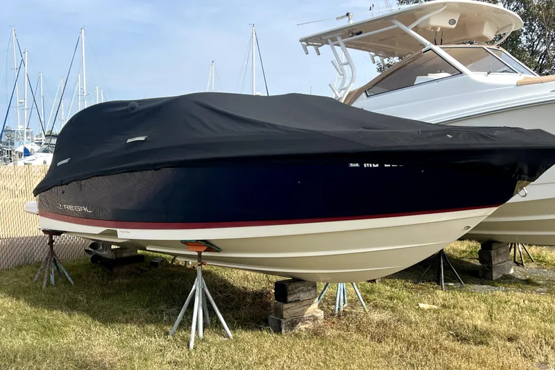 Slide: The Image of 2016 Regal 2300 Bowrider boat covered and elevated on stands in a marina. - 11