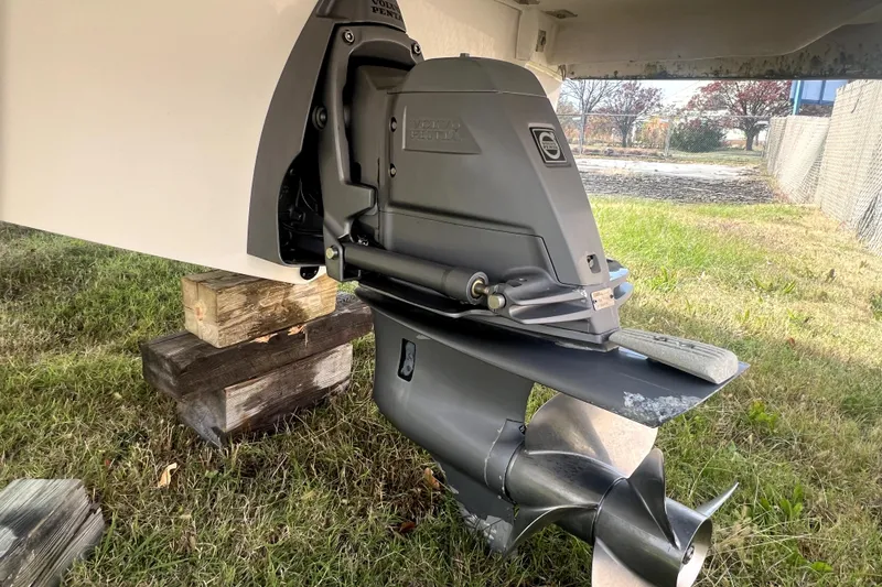 Slide: The Image of 2016 Regal 2300 Bowrider boat outdrive on grass, supported by wooden blocks. - 13