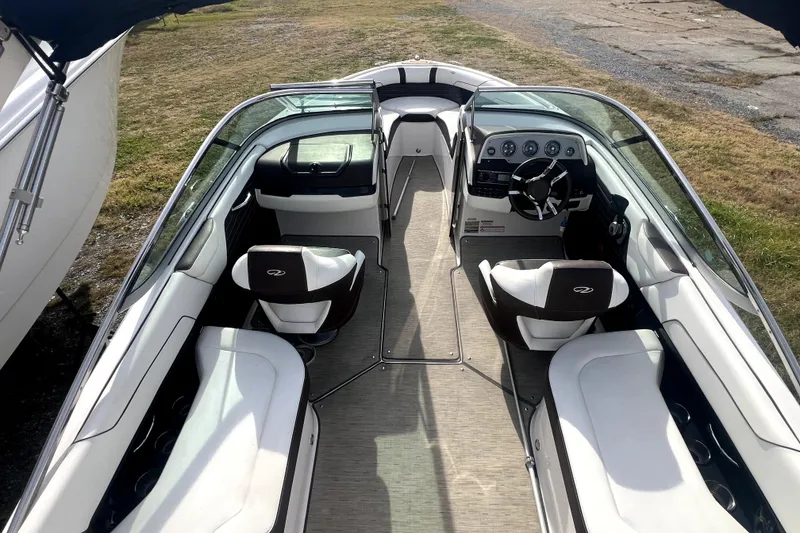 Slide: The Image of 2016 Regal 2300 Bowrider interior with seating and dashboard, parked on grass. - 6