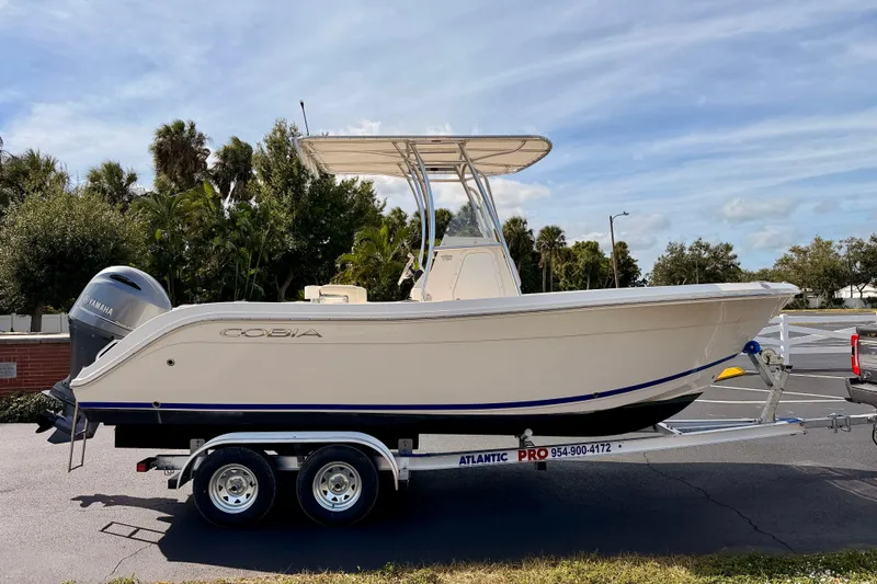 Slide: The Image of 2023 Cobia 220 Center Console boat on trailer, parked outdoors. - 1