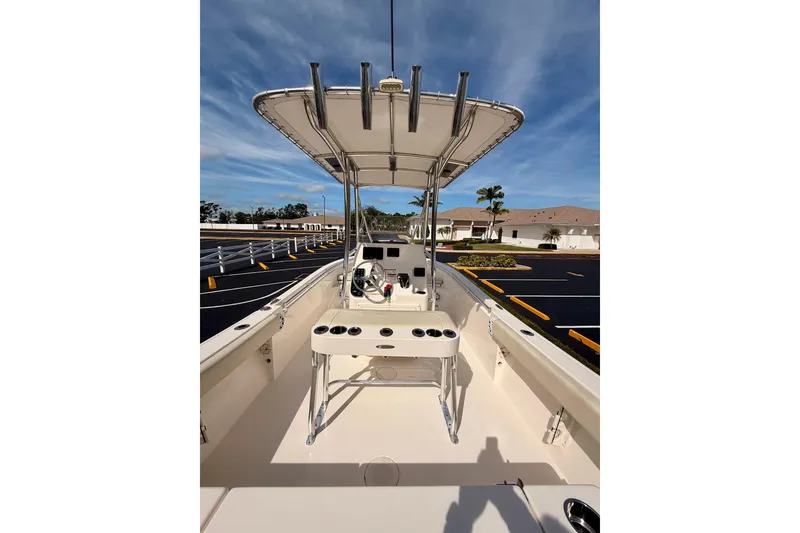 Slide: The Image of 2023 Cobia 220 Center Console boat with T-top in a parking lot. - 14