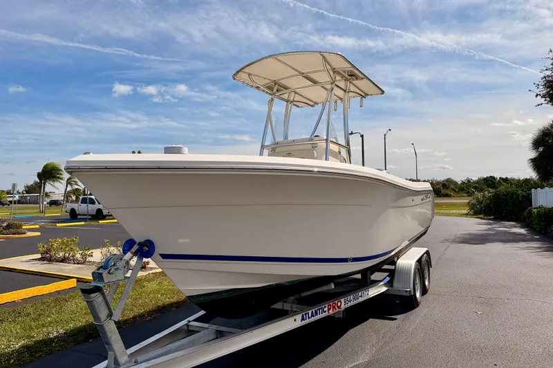 Slide: The Image of 2023 Cobia 220 Center Console boat on trailer under clear sky. - 2