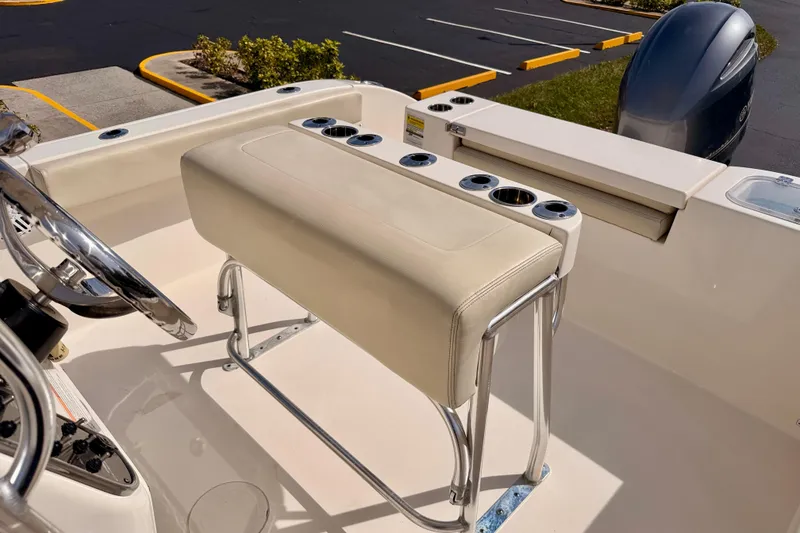 Slide: The Image of 2023 Cobia 220 Center Console boat interior with helm seat and rod holders. - 23