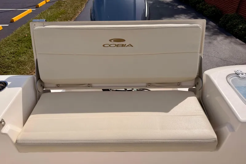 Slide: The Image of 2023 Cobia 220 Center Console boat seat, beige upholstery, outdoor setting. - 26
