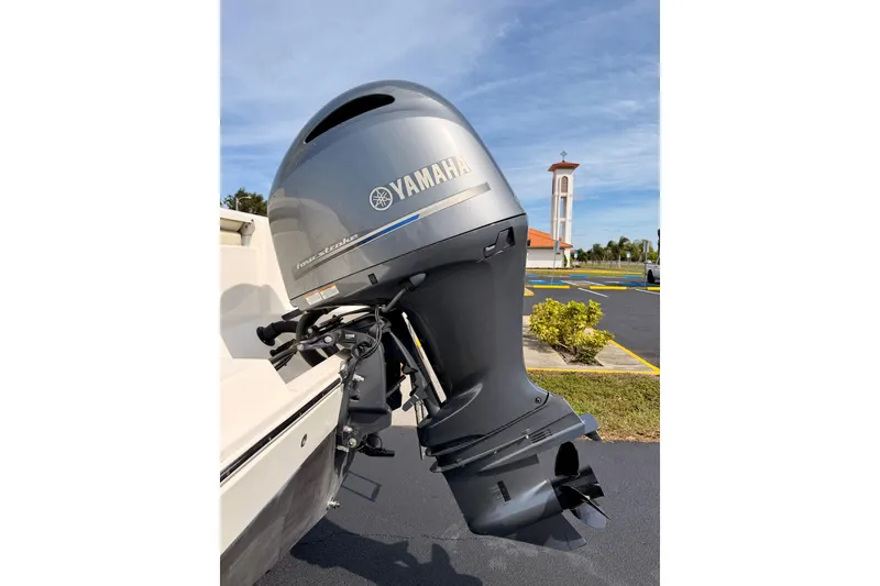 Slide: The Image of 2023 Cobia 220 Center Console with Yamaha outboard motor in a parking lot. - 32