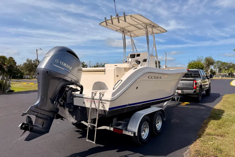 Slide: The Image of 2023 Cobia 220 Center Console boat on trailer, with Yamaha engine, parked outdoors. - 4
