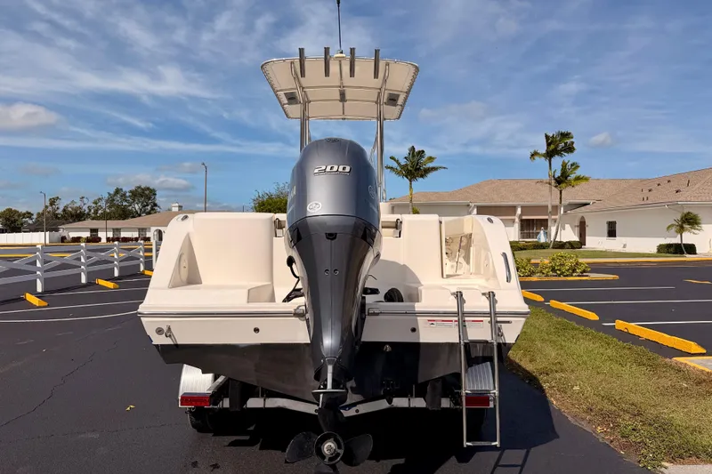 Slide: The Image of 2023 Cobia 220 Center Console boat with 200 HP engine in parking lot. - 5