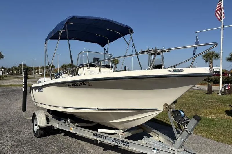 Slide: The Image of 2004 Key West 186 Sportsman boat on trailer with blue canopy, parked outdoors. - 4