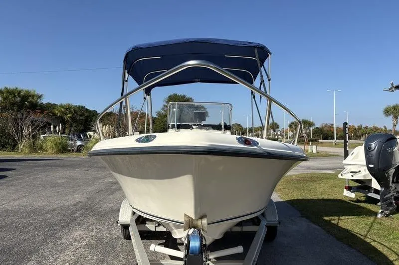 Slide: The Image of 2004 Key West 186 Sportsman boat on trailer with blue canopy, parked outdoors. - 7
