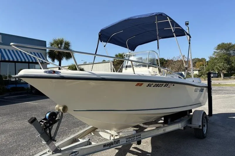 Slide: The Image of 2004 Key West 186 Sportsman boat on trailer with blue canopy. - 8