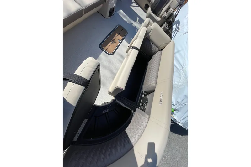 Slide: The Image of 2026 Harris Cruiser 250 boat interior with open storage compartment and cup holders. - 10