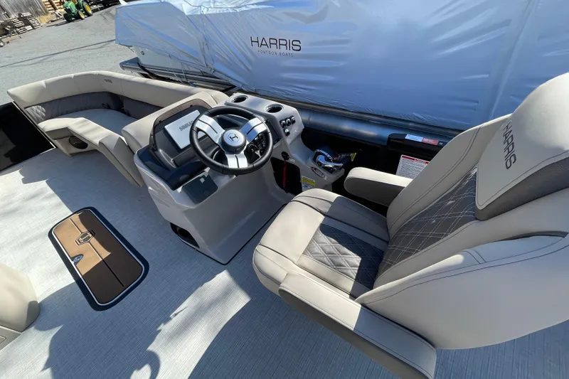 Slide: The Image of 2026 Harris Cruiser 250 pontoon boat interior with steering wheel and seating. - 13