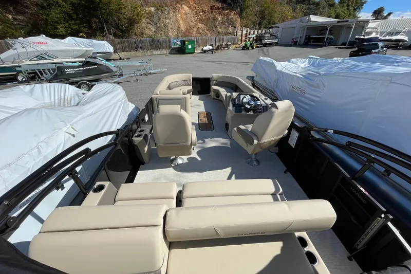 Slide: The Image of 2026 Harris Cruiser 250 pontoon boat with beige seating, docked outdoors. - 28