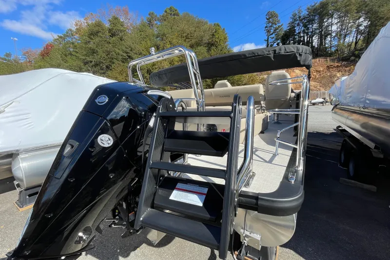 Slide: The Image of 2026 Harris Cruiser 250 pontoon boat with outboard motor and rear entry ladder. - 6