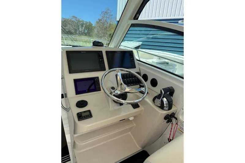 Slide: The Image of 2019 Boston Whaler 315 Conquest helm with modern navigation displays and controls. - 10